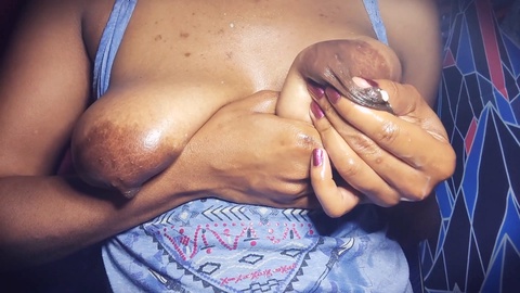 Bella donna dalla pelle scura con capezzoli turgidi esplora l'olio Yoni per l'allattamento
