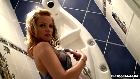 Süße Regina, eine rot-heiße blonde Teenagerin, verwöhnt sich unter der Dusche ihren Kitzler
