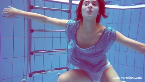 La jeune et séduisante Marusia, une adolescente russe à la piscine, se baigne nue sous l'eau