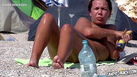 Milf amatoriale nudista dalle grandi tette catturata da una telecamera nascosta a prendere il sole sulla spiaggia