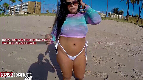 Kriss, la femme chaude, se promène sur la plage sans soutien-gorge avec un top transparent