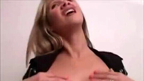 Chaude cougar blonde Hot Wife Rio fait une fellation douce et chaude avec ses gros seins en silicone en exhibition, portant des bas et des talons hauts