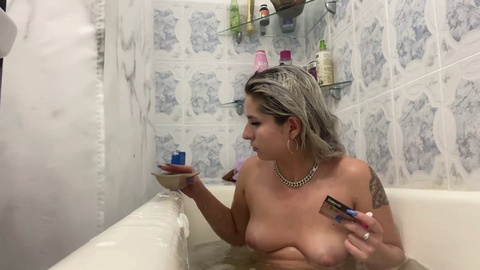Sexy blonde spielt mit sich selbst, während sie eine Zigarette raucht und ein heißes Bad nimmt