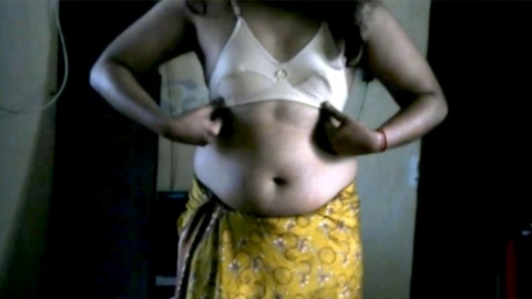Sinnlicher indischer Crossdresser Krithi neckt mit ihrem trainierten Bauchnabel in einem gelben Sari und spielt dabei mit ihren hüpfenden Brüsten und großen schwarzen Nippeln.