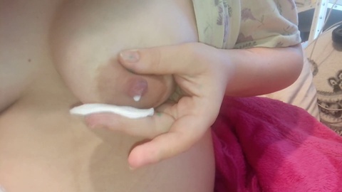 Eine junge Mutter hat Milch, die aus ihren Brüsten fließt
