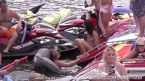 Bikini-clad and topless women at a wild public party cove
