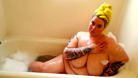 Une BBW tatouée et sexy se détend dans un bain moussant et se donne du plaisir !