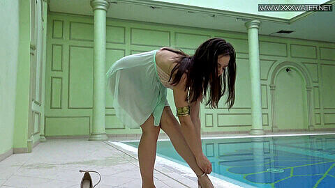 La seductora adolescente de constitución pequeña, Lizi Vogue, disfruta de un baño desnuda en la piscina.